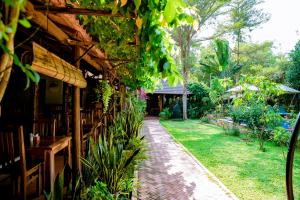 a patio of a restaurant with tables and plants at La Mer Resort, Phú Quốc in Phú Quốc