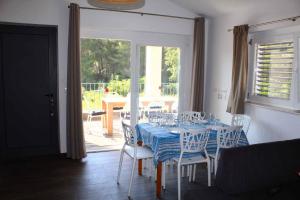una sala da pranzo con tavolo, sedie e una finestra di Apartment Veli Rat - Insel Dugi Otok 37001 a Veli Rat
