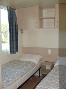 Habitación pequeña con 2 camas y ventana en Mobilehomes in Cavallino-Treporti 33773 en Cavallino-Treporti