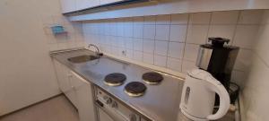 eine Küche mit einer Theke mit einer Spüle und einer Kaffeemaschine in der Unterkunft Apartment Bad Mitterndorf/Steiermark 432 in Bad Mitterndorf