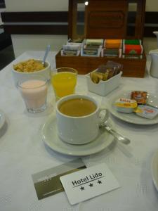 - une tasse de café assise sur une table avec une assiette de nourriture dans l'établissement Hotel Lido, à Mar del Plata