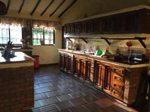 a large kitchen with wooden cabinets and a counter at Villa Calusa in Villeta