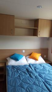ein Bett mit zwei Kissen darüber in der Unterkunft Mobilehomes in Rosolina Mare 33791 in Rosolina Mare