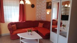 ザラカロシュにあるApartment in Zalakaros/Thermalbad 20663のリビングルーム(赤いソファ、テーブル2台付)