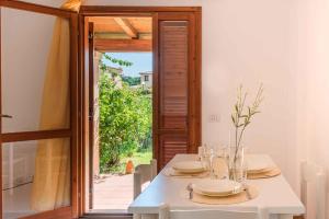 a dining room with a white table and an open door at Holiday home in San Teodoro 26875 in San Teodoro