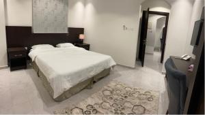 Schlafzimmer mit einem Bett, einem Tisch und einem Spiegel in der Unterkunft فندق كنان سويت in Sulţānah