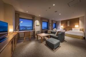 静岡市にあるホテルアソシア静岡のベッドとテレビが備わる広いホテルルームです。