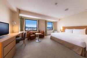 a hotel room with a bed and a flat screen tv at Hotel Associa Shizuoka in Shizuoka