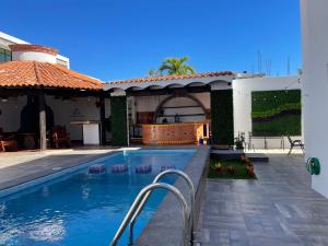 a swimming pool in front of a house at Departamentos Luminar in Mazatlán