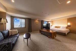 a living room with a couch and a television at Hotel Associa Shizuoka in Shizuoka