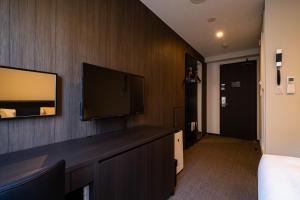 a hotel room with a flat screen tv on a wall at Hotel Shuranza Chiba in Chiba