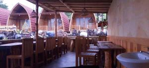 a restaurant with wooden tables and chairs and a counter at Manik Tirta Cabin's in Kintamani