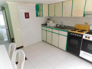 a kitchen with green and white cabinets and a stove at Los muiscas in Tunja