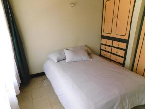 een kleine slaapkamer met een bed en een kast bij Los muiscas in Tunja