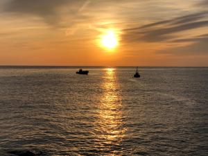 zwei Boote im Ozean bei Sonnenuntergang in der Unterkunft Izu Shirada Villa 伊豆白田家 in Higashiizu