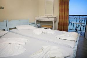 two beds with towels on them in a room with a balcony at Michaelia Hotel in Petra