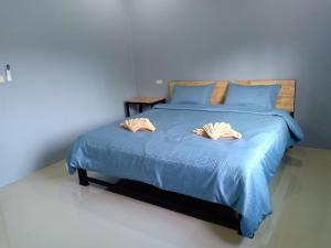 a bedroom with a blue bed with two pillows at กฤษณ์ศิริเฮ้าส์ in Chiang Rai