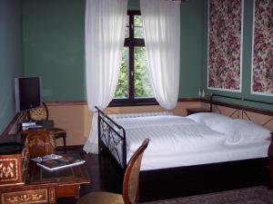 a bedroom with a bed and a window at Gutshaus Kubbelkow in Bergen auf Rügen