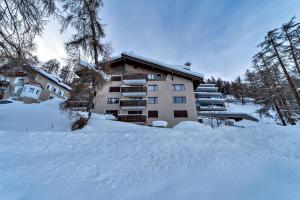 a building in the snow with a pile of snow at Chesa Aruons 21 - St. Moritz in St. Moritz
