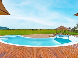 
a pool with a lawn chair and a pool table at One Nature Nyaruswiga Serengeti in Banagi
