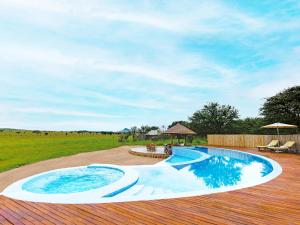 a large swimming pool on a wooden deck at One Nature Nyaruswiga Serengeti in Banagi