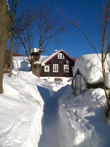 a house covered in snow with a driveway at Trzy kultury Złoty Widok in Szklarska Poręba