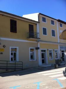 un gran edificio amarillo con balcón en una calle en Apartment Mandrač, en Novigrad Istria