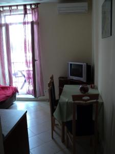 Habitación con mesa, TV, mesa y silla. en Apartment Mandrač, en Novigrad Istria
