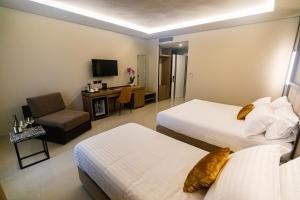 a hotel room with two beds and a chair at Kraal Hotel Vlore in Vlorë