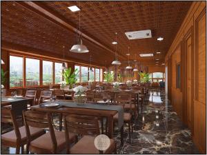 a dining room with tables and chairs and windows at TheKing Hotel in Hương Gia