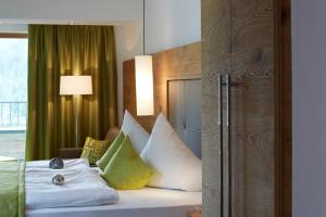 a bedroom with a bed with pillows on it at Hotel Garni Fimba in Ischgl