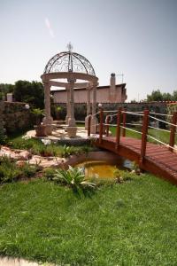 a wooden bridge over a pond with a gazebo at Il Mondo B&B in Fiumicino