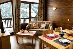 uma sala de estar com um sofá e uma mesa em Lagrange Vacances Les Chalets du Mont Blanc em Hauteluce