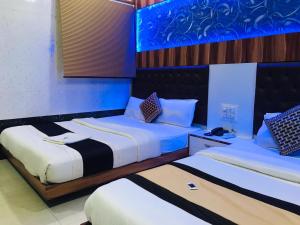 2 camas en una habitación de color azul y blanco en Hotel Royal Inn Mangalore - Opp SDM Law College MG Road, en Mangalore
