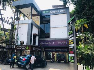 ein Gebäude mit einem davor geparkt in der Unterkunft Hotel Royal Inn Mangalore - Opp SDM Law College MG Road in Mangaluru