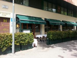 a restaurant with tables and chairs in front of a building at La Ciudadela in Barcelona