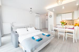a white bedroom with a bed and a dining room at Bella Casa Premium Apartment - 30 Pszczelna in Krakow