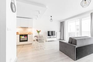 a white living room with a couch and a kitchen at Bella Casa Premium Apartment - 30 Pszczelna in Krakow