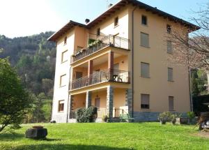 a large building with a grass field in front of it at Casa del Faggio Rosso in Bellagio