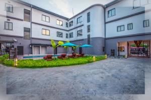 an apartment building with a courtyard with chairs and umbrellas at AKWA HIN Douala in Douala