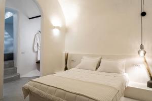 a white bedroom with a large bed with white pillows at Terra e Lavoro Luxury Suites in Éxo Goniá