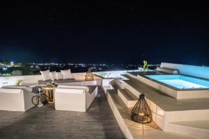 an outdoor patio with a swimming pool at night at Terra e Lavoro Luxury Suites in Éxo Goniá