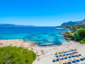 una vista aerea su una spiaggia con ombrelloni e sull'oceano di Sant Vicenç, amazing house in Alcudia for 6 a Alcudia