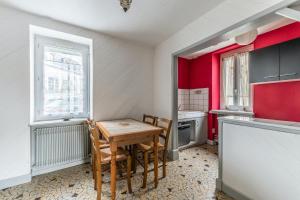 a small kitchen with a wooden table and chairs at Maison conviviale à Bourbon-Lancy avec équipements modernes in Bourbon-Lancy
