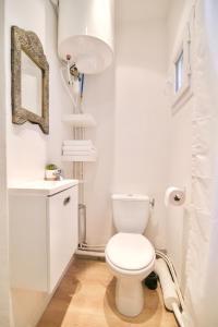 a white bathroom with a toilet and a mirror at Au coeur de Sanary-sur-Mer studio cosy in Sanary-sur-Mer