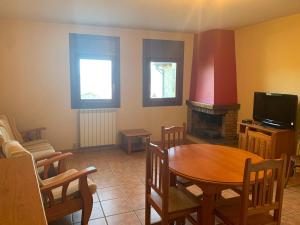 a living room with a table and a fireplace at Ca L'Isidret in Lles