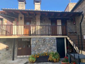 a house with a balcony and flowers in front of it at Ca L'Isidret in Lles