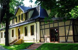 een groot geel huis met een deur en een trap bij Villa Toskana in Pogorzelica