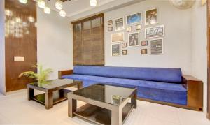 a living room with a blue couch and a table at Itsy By Treebo - City Centre Noida in Noida