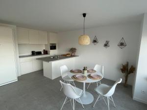 uma cozinha com uma mesa e cadeiras numa cozinha em Beau séjour em Bredene